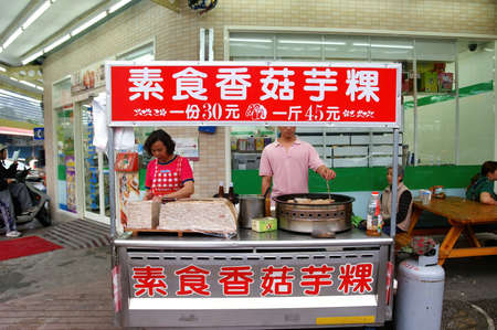Tainan, APR 3, 2005 - Man frying Taro Cake outside of a convenience storeのeditorial素材