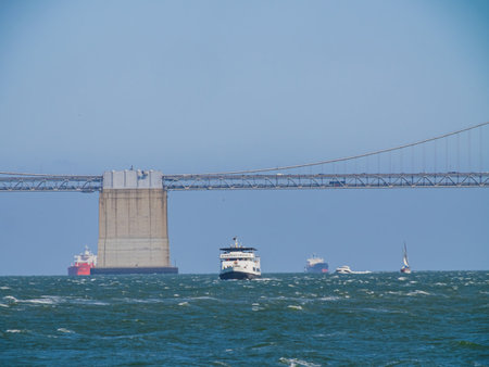 San Francisco, MAY 19, 2021 - Sunny view of a cruise passing by the San Francisco Oakland Bay Bridgeのeditorial素材