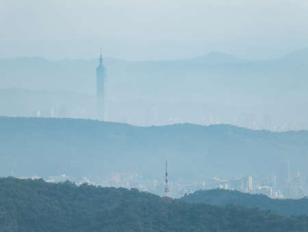 Hazy view of the Taipei 101 and cityscape from a far mountain at Taipei, Taiwanの写真素材