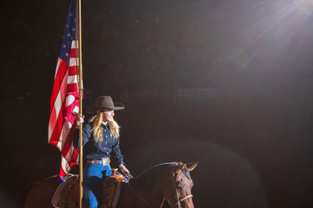 Fort Worth, NOV 27 2021, Cowgirl holding America flag in the Stockyards Championship Rodeoのeditorial素材