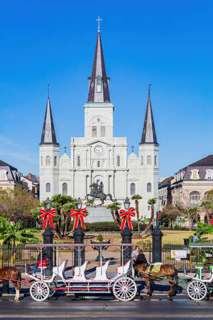 Louisiana, DEC 24 2021 - Sunny view of the historical St. Louis Cathedral with many mid centry carriage at French Quarterのeditorial素材