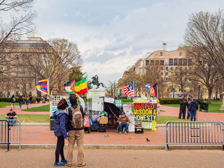 Washington DC, MAR 31 2022 - Man protest with sign and flags in Lafayette Squareのeditorial素材