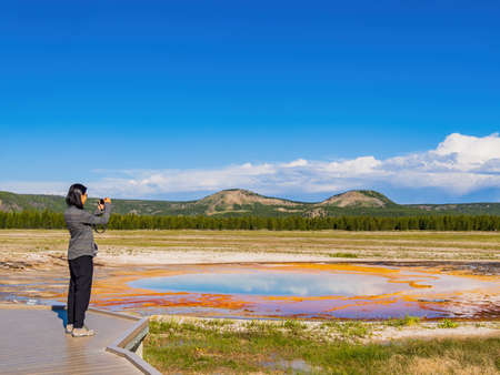 Woman taking picture of the beautiful Opal Pool at Wyomingの写真素材
