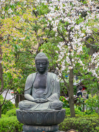Tokyo, APR 6 2013 - Close up shot of a buddhist statue with Cherry blossomのeditorial素材