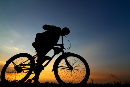 silhouette of the cyclist riding a road bike at sunset at Thailandの写真素材