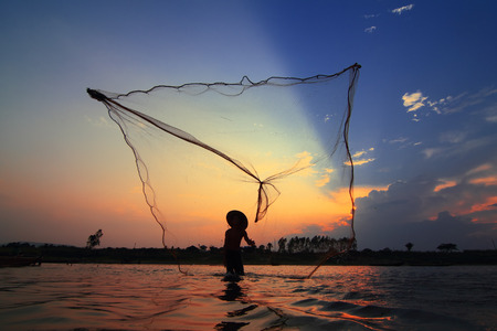 Casting a silhouette at sunsetの写真素材