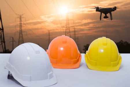 Safety helmet stacked in the background sunset high voltage poleの写真素材