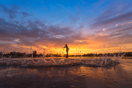 Silhouette fisherman on boat ,fishingman net, fishingman on boat, fisherman silhouette,fisherman boat, fishing with nets in the morning in Thailandの写真素材