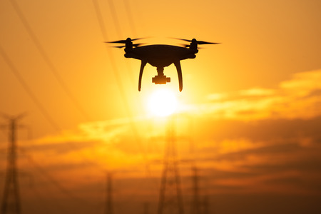 Drone surveying High voltage towers the sunset backgroundの写真素材