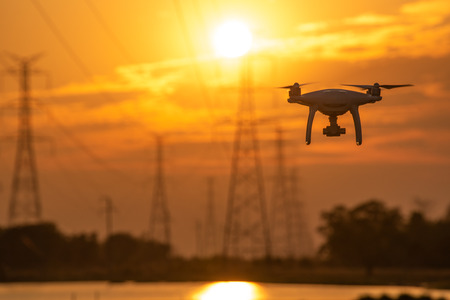 Drone surveying High voltage towers the sunset backgroundの写真素材