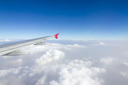 An airplane wing in the sky The sky atmosphere is cloudy and dust is thick. Fly on the Asian continent, Thailand.の写真素材
