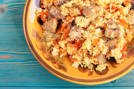 pilau from rice, meat, carrot and barberry in yellow plateの写真素材