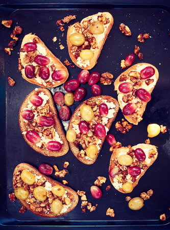 toasts with ricotta, baked grapes and walnutの写真素材