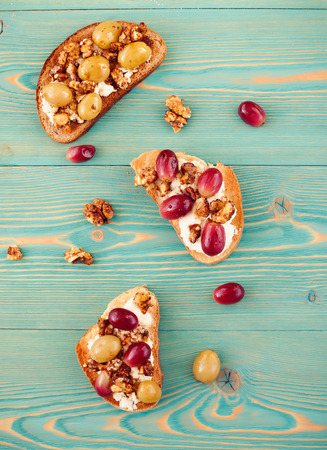 rye and wheat toasts with baked grape on blue tableの写真素材