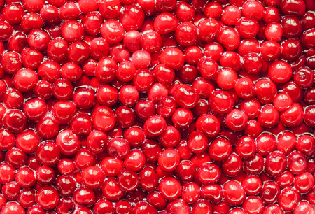 red fresh cherries with pits in sugar syrup: looks like smilingの写真素材