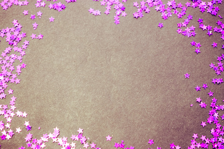 Purple glitter stars on a black background with copy spaceの写真素材