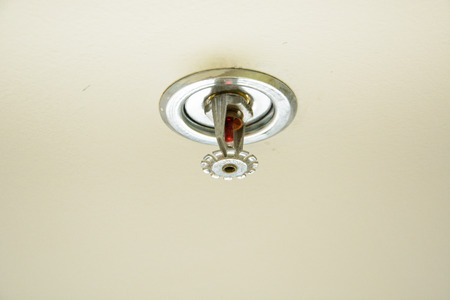 a fire sprinkler on the ceilingの写真素材
