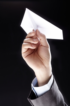 Handmade white origami paper plane isolated on black backgroundの写真素材