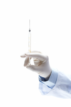 hand in glove with syringe on white isolated on white backgroundの写真素材