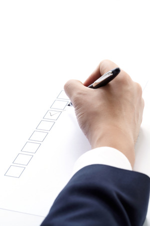 filling of questionnaire a person by a pen on white backgroundの写真素材