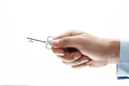 hand holding key on isolated on white backgroundの写真素材