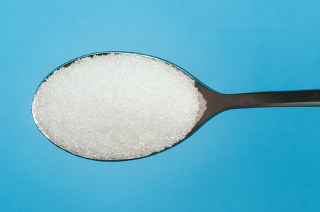 Sugar spoon blue background.の写真素材