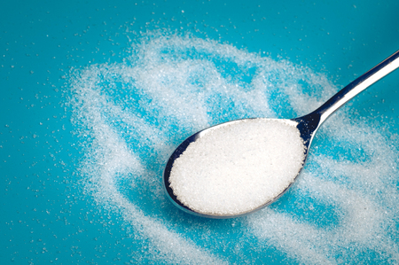 white Sugar spoon blue background.の写真素材