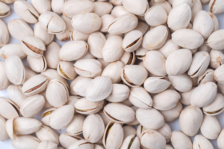 Roasted and salted pistachios in shell on white background.の写真素材