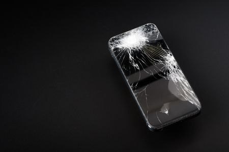 Smartphone with broken screen on dark backgroundの写真素材