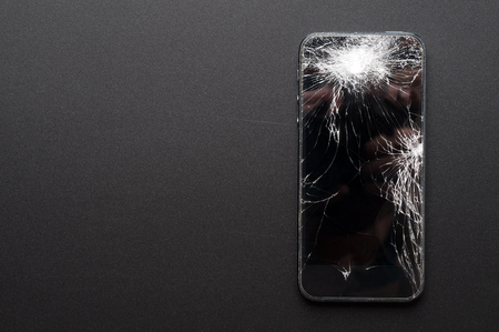 Smartphone with broken screen on dark backgroundの写真素材