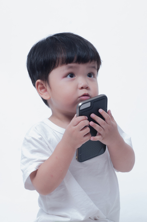 boy playing in a mobile phone on white background.の写真素材