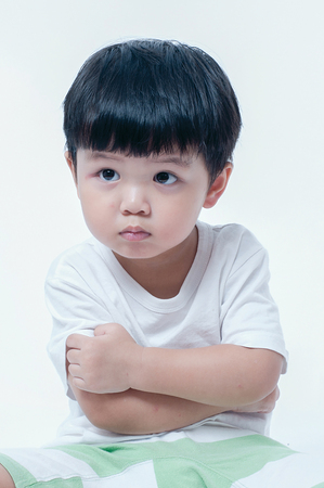 Little boy itchy his arm on white background.の写真素材
