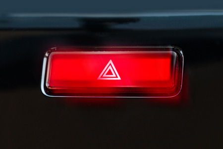 pushed red warning button with triangle pictogram and flasher light.の写真素材