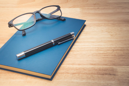 Blue leather notebook and pen on wood backgroundの写真素材