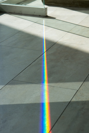 A glass spliting sunlight into spectrum colorsの写真素材