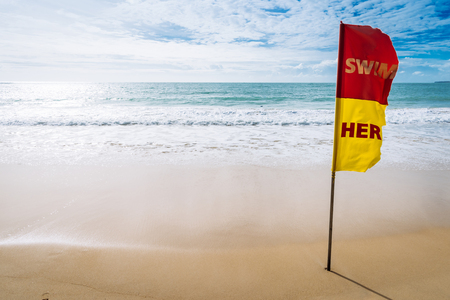 swim here red and yellow flag on the beachの写真素材