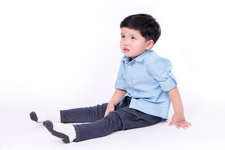 Portrait of crying little boy on white background.の写真素材