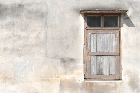 Old grunge wooden window isolated on cement wall.の写真素材