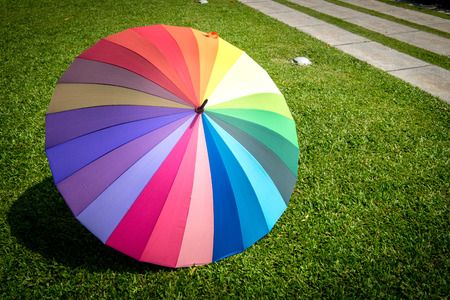 rainbow umbrella in grass field vintage and retro tone, soft focus.の写真素材