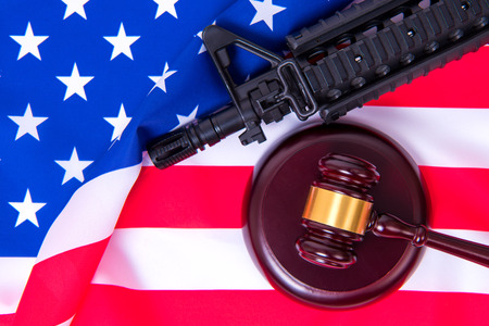 Gavel with gun on background of USA flagの写真素材
