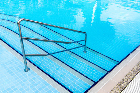 Swimming pool with stair at hotel close up