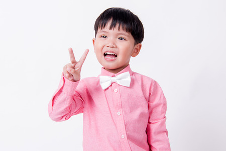 Smiling boy wears formal pink shirt and bow tieの写真素材
