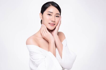 Beautiful Young Asian Woman with Clean Fresh Skin is touching her faceの写真素材