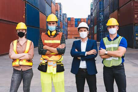 Construction team and a business man with blue suit show confident at construction site. All of them are wearing face mask.の写真素材