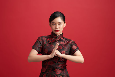 Asian chinese woman in traditional dress on red background. Chinese new year festival.
