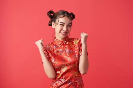 Asian chinese woman in traditional dress on red background. Chinese new year festivalの写真素材