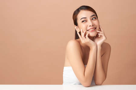 Beautiful young asian woman with clean fresh skin on beige background, Face care, Facial treatment, Cosmetology, beauty and spa, Asian women portraitの写真素材