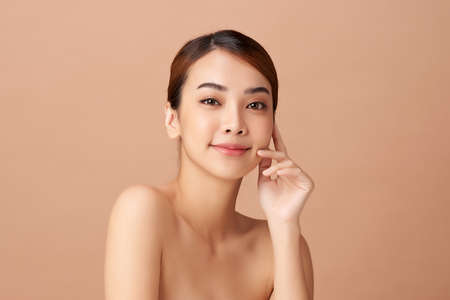 Beautiful young asian woman with clean fresh skin on beige background, Face care, Facial treatment, Cosmetology, beauty and spa, Asian women portraitの写真素材