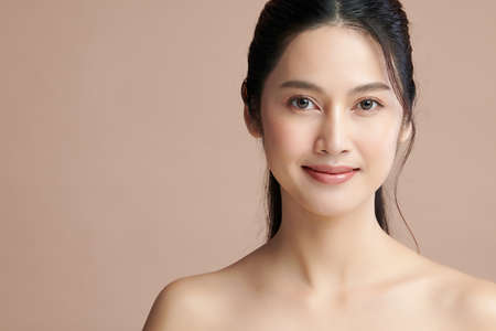 Beautiful young asian woman with clean fresh skin on beige background, Face care, Facial treatment, Cosmetology, beauty and spa, Asian women portrait.の写真素材