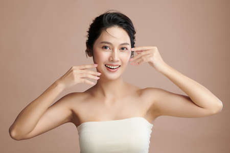 Beautiful young asian woman with clean fresh skin on beige background, Face care, Facial treatment, Cosmetology, beauty and spa, Asian women portrait.の写真素材